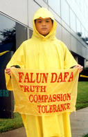 A little Falun Dafa Practitioner holding a sign of the Universal Characteristic, clarifying the truth in Houston, Texas.
        
        