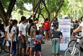 '在巴厘岛，公园里的人们驻足观看揭露中共活摘器官的展板'