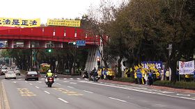 '北京市长郭金龙车队（左），二月十九日早上行经台北市中山北路时，遇到法轮功学员拉横幅抗议，立即加快车速仓皇而逃。'