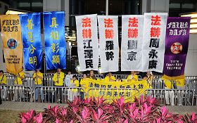 法轮功学员在中联办门前，张起法办江、罗、刘、周等迫害元凶的幡旗，并宣读声明