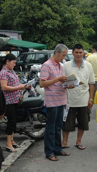 '游行队伍走过后，市民继续在路旁阅读真相资料。'