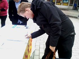 这位外籍留学生在了解迫害真相后，在“反迫害征签表”上签名。
