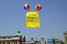活动现场首尔站上空飘扬着“庆祝法轮大法洪传20周年”的大型气球。