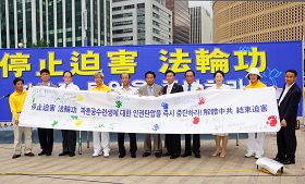'首尔广场反迫害联合集会上，各界代表在反迫害征签大横幅上按手印并签名谴责中共对法轮功的迫害'