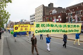 多伦多法轮功学员及各界人士在多伦多市区游行，庆祝法轮大法洪传二十一周年。