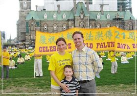'二零一三年五月八日，加拿大首都渥太华国会山前，德鲁与妻子及儿子在法轮大法传世二十一周年庆祝活动现场'