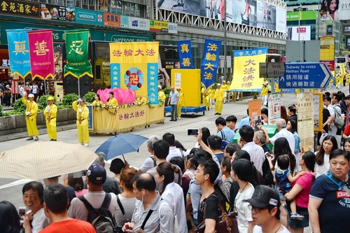 Wisatawan dan penduduk Hong Kong mengambil video dan gambar pawai akbar praktisi Falun Gong.