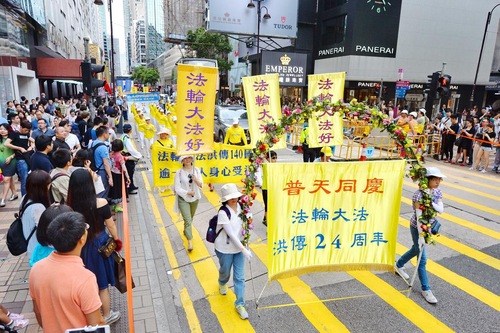 Wisatawan dan penduduk Hong Kong mengambil video dan gambar pawai akbar praktisi Falun Gong.