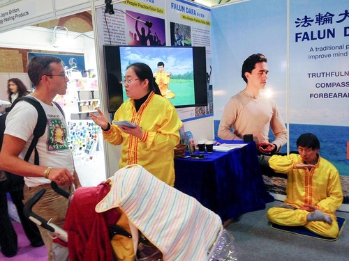 Alexandra Palace di London, Seorang pengunjung pameran mempelajari tentang latihan Falun Gong.