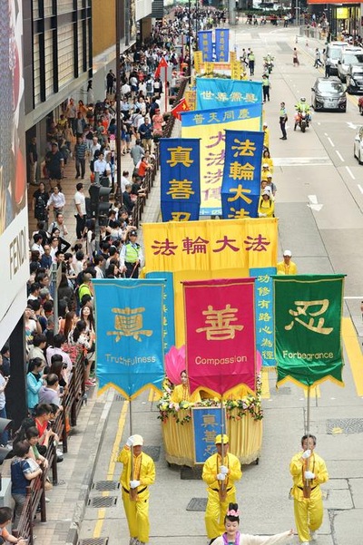 Wisatawan dan penduduk Hong Kong mengambil video dan gambar pawai akbar praktisi Falun Gong.