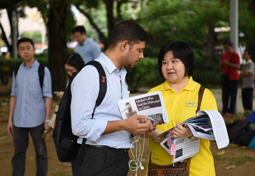 Para turis mempelajari tentang penindasan di Tiongkok dari praktisi.