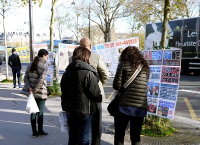 Wisatawan Tiongkok membaca materi di spanduk dan poster Falun Gong - mundur dari Partai Komunis