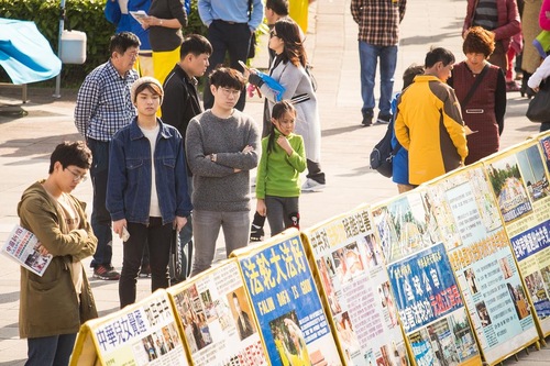 Para wisatawan mempelajari tentang Falun Gong dan penganiayaan di Tiongkok