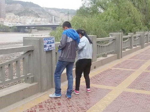 Dua remaja membaca poster di Kota Lanzhou, Provinsi Gansu