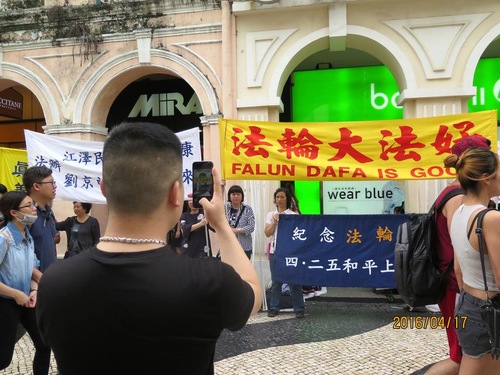 Seorang turis Tiongkok mengambil foto acara Falun Gong.