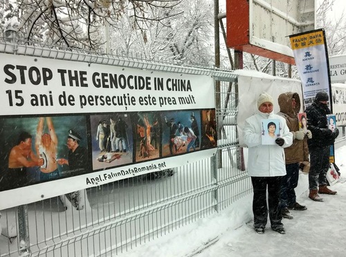 Praktisi dengan penuh damai memprotes di depan Kedutaan Besar Tiongkok sambil memegang foto praktisi Falun Gong yang telah meninggal akibat penganiayaan rezim komunis Tiongkok.