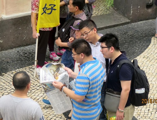 Turis Tiongkok membaca materi Falun Gong