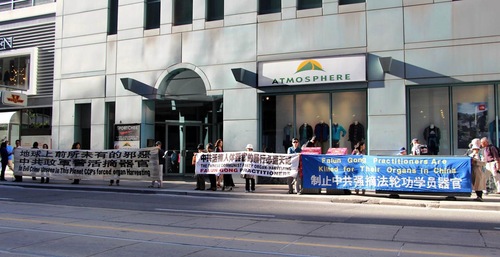 Praktisi Falun Gong memegang spanduk untuk menyampaikan pesan tuntutan hukum terhadap Jiang Zemin