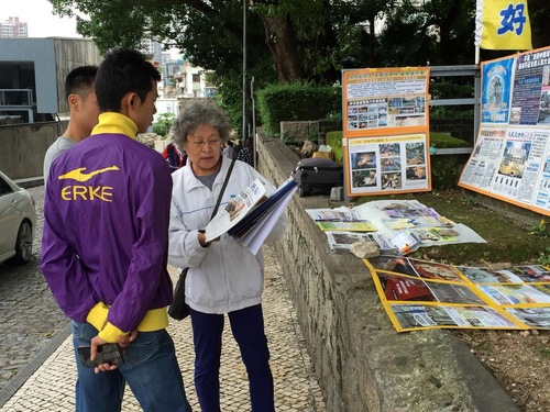 Seorang Praktisi Falun Gong berbicara dengan dua pemuda tentang tuntutan hukum terhadap Jiang Zemin.