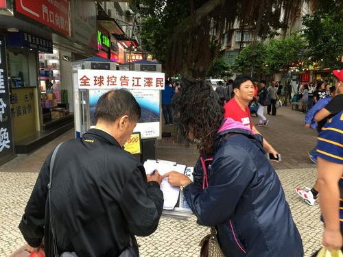 Orang-orang menandatangani petisi mendukung perlawanan damai Falun Gong.