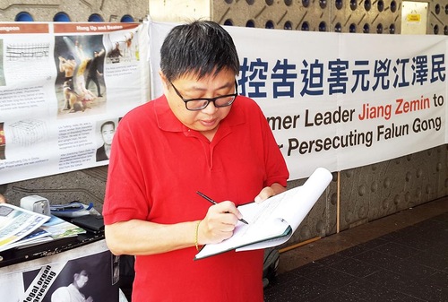 John Hugh, Anggota Dewan Kota Parramatta, menandatangani petisi untuk mendukung tuntutan hukum terhadap mantan diktator Tiongkok, Jiang Zemin