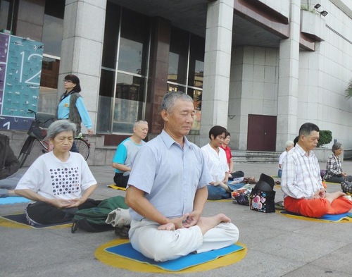 Hsu dan rekan-rekan praktisi berlatih meditasi Falun Dafa