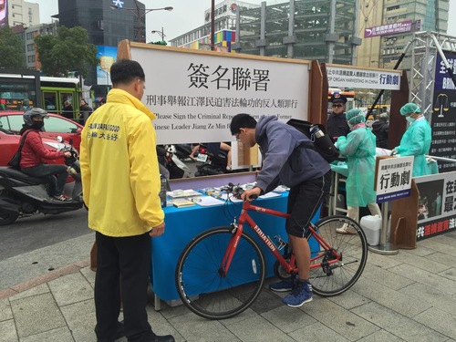 Seorang pengendara sepeda berhenti untuk menandatangani petisi