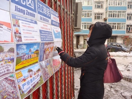 Orang yang lewat membaca poster di Kota Harbin, ibu kota Provinsi Heilongjiang. Selain Heilongjiang, provinsi terdingin di Tiongkok, poster serupa juga terlihat di dua provinsi lainnya di timur laut, Jilin dan Liaoning.