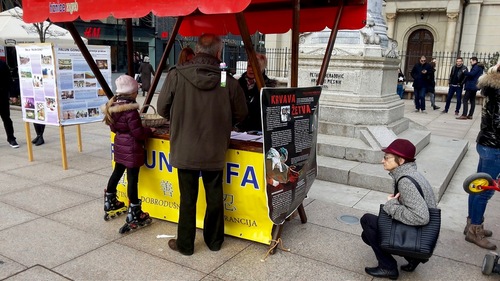 Pejalan kaki mempelajari tentang pengambilan organ dengan membaca poster dan berbicara dengan praktisi Falun Dafa
