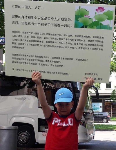 Seorang praktisi muda membawa poster informasi dalam bahasa Mandarin untuk meningkatkan kesadaran akan watak asli Partai Komunis, dan menyarankan agar mundur dari keanggotaan partai komunis