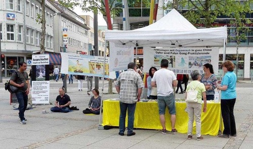 Para pejalan kaki di Heidenheim an der Brenzberhenti di stan praktisi untuk mempelajari lebih lanjut tentang Falun Gong