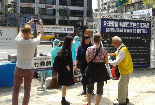 Praktisi Falun Gong di Taipei meningkatkan kesadaran penganiayaan di Tiongkok. Seorang praktisi menjelaskan gambar mengerikan kepada pejalan kaki.