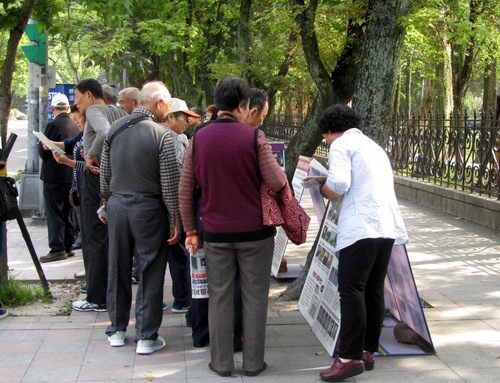 Wisatawan Tiongkok mempelajari materi Falun Gong.