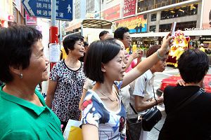 市民及游客纷纷拿起手机、相机，拍摄游行的盛况。