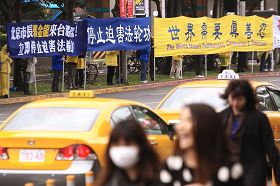 '十七日中午，台北市长郝龙斌与北京市长郭金龙在台北一零一餐叙，一零一大楼外广场早有法轮功学员拉横幅与静坐抗议，呼吁制止中共迫害法轮功。'
