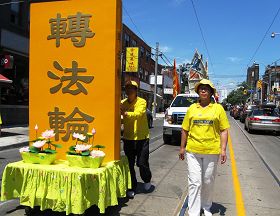 吴燕霞（右）参加二零一二年多伦多庆祝法轮大法日大游行经过唐人街